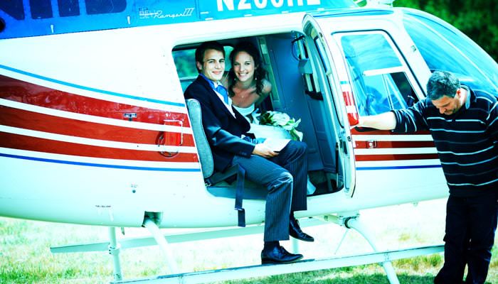 Wedding photograph of Rosie and Mark getting out of helicopter at the reception in Somerset Wedding Photographer for Rosie & Mark at Sherborne Abbey, Dorset