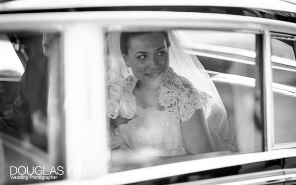 Bride photographed in car leaving ceremony