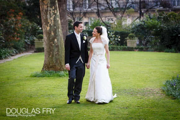 Bride and groom photographed walking in front of Berekeley Hotel in London