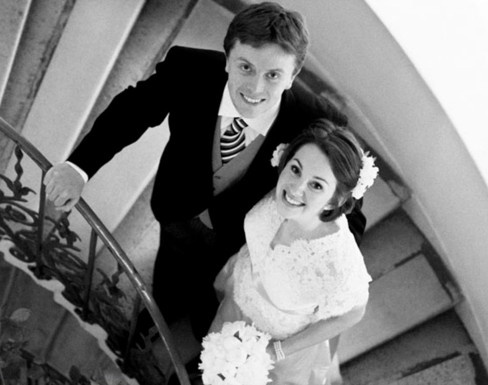 Couple on stair case at Queens House in London pictured in black and white