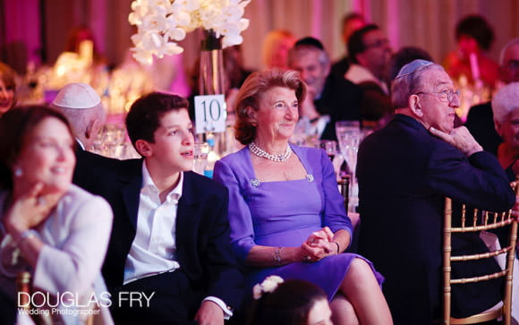 Guests listening to speeches during wedding reception