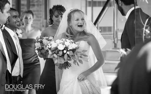 Bride laughing as she arrives at HTB for her wedding - photographed by Douglas Fry