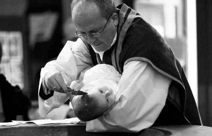 vicar blessing baby during christening service Josh's Christening Photographer 1