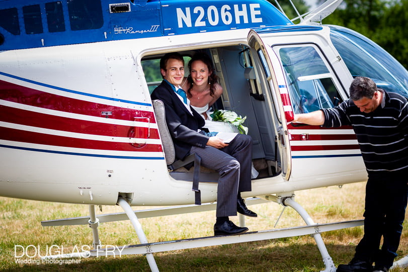 Bride and groom photographed arriving by helicopter for wedding reception in Dorset