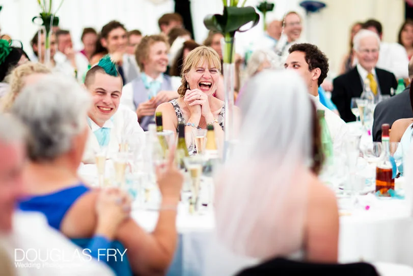 Wedding Photographer for Rosie & Mark at Sherborne Abbey, Dorset 15 speaches - laughter in marquee during wedding in countryside