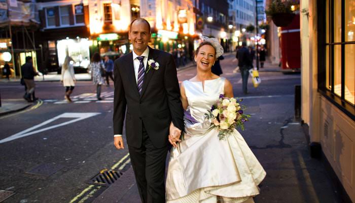 Wedding photograph of bride and groom outside restaurant in Soho, London