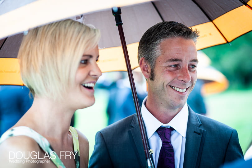 Couple under umbrella at Coworth Park