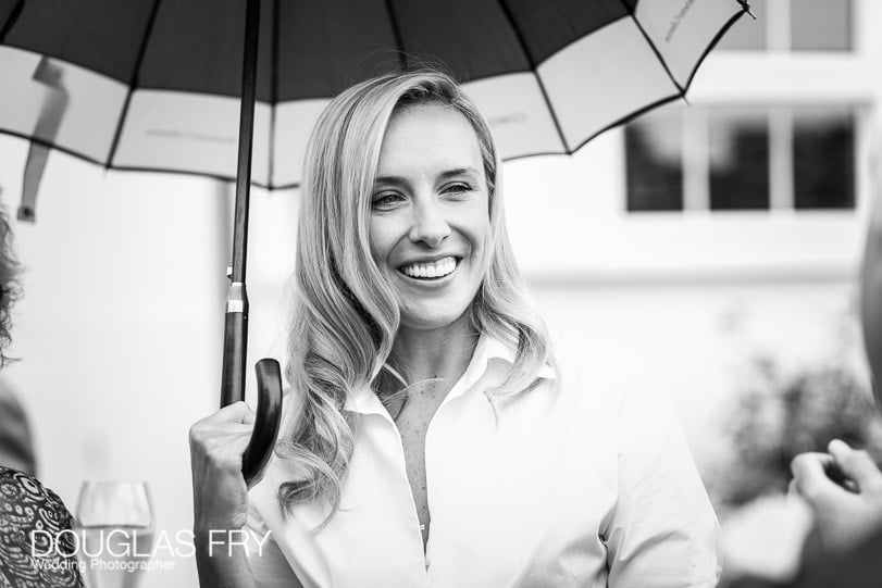 Guest photographed with umbrella at wedding reception