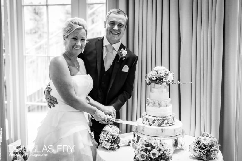 Wedding photograph of couple cutting wedding cake made of cheeses