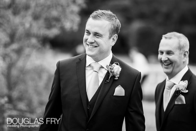 Groom photographed in black and white at gardens of Coworth House