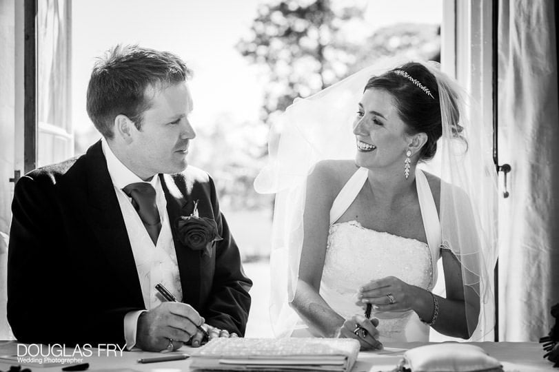 couple signing register photographed at Cambridge Cottage Kew by wedding photographer