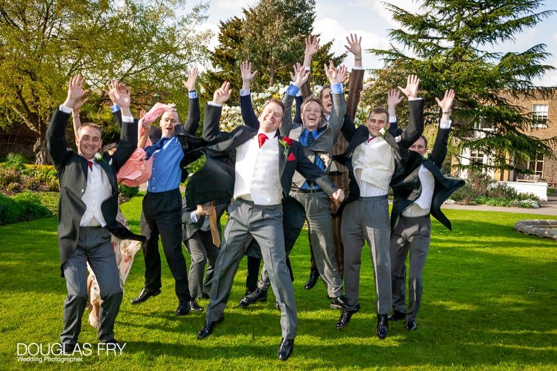 groom and ushers jumping photographed at Cambridge Cottage Kew by wedding photographer