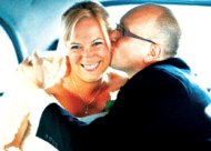 Bride and groom kiss in back of London cab