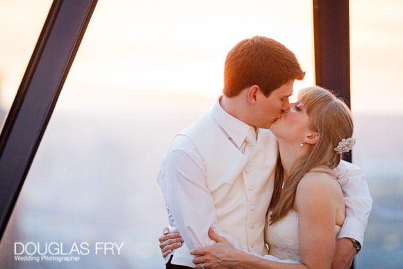 Wedding photograph of couple kissing with sunset behind view out of Gherkin window