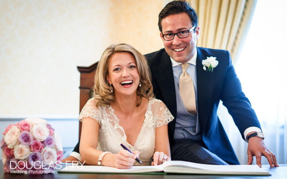 Wedding photographer - couple signing register in Chelsea Register office