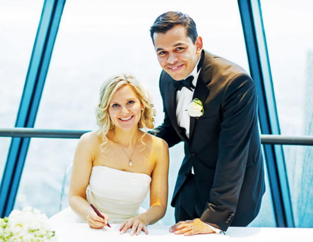 Wedding photograph of couple at Gherkin signing register at end of wedding