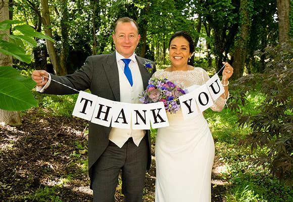 Wedding Photograph - couple with thank you sign for cards