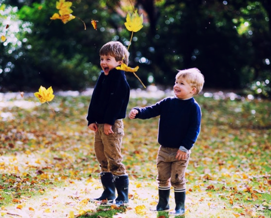 family photographer london - children playing with leaves in park