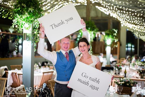 Wedding Thank You Card Tips and Ideas 2 Couple at reception with thank you sign