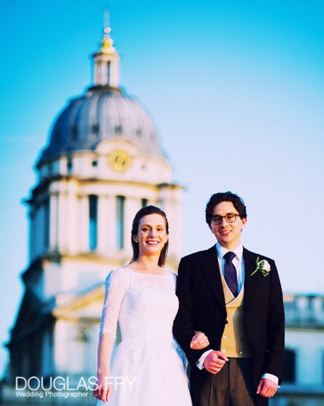 Bride and Groom with Old Royal NAval Collage behind them, with beautiful blue sky.