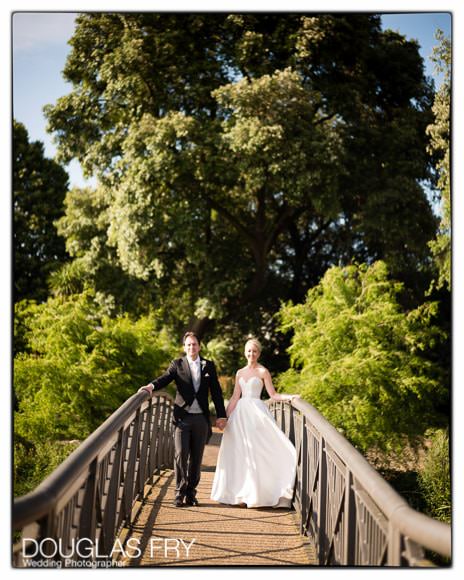 Bride and groom photographed on bridge in the gardens of Syon Park