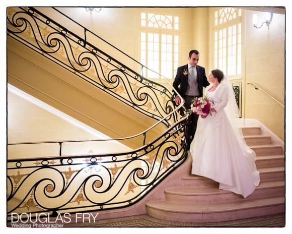 Bride and groom on stairs at Hotel Cafe Royal in London