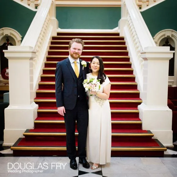 Saturday's wedding at Woolwich Register Office and The Gun, Docklands 5 Couple on stairs in Woolwich being photographed after wedding ceremony