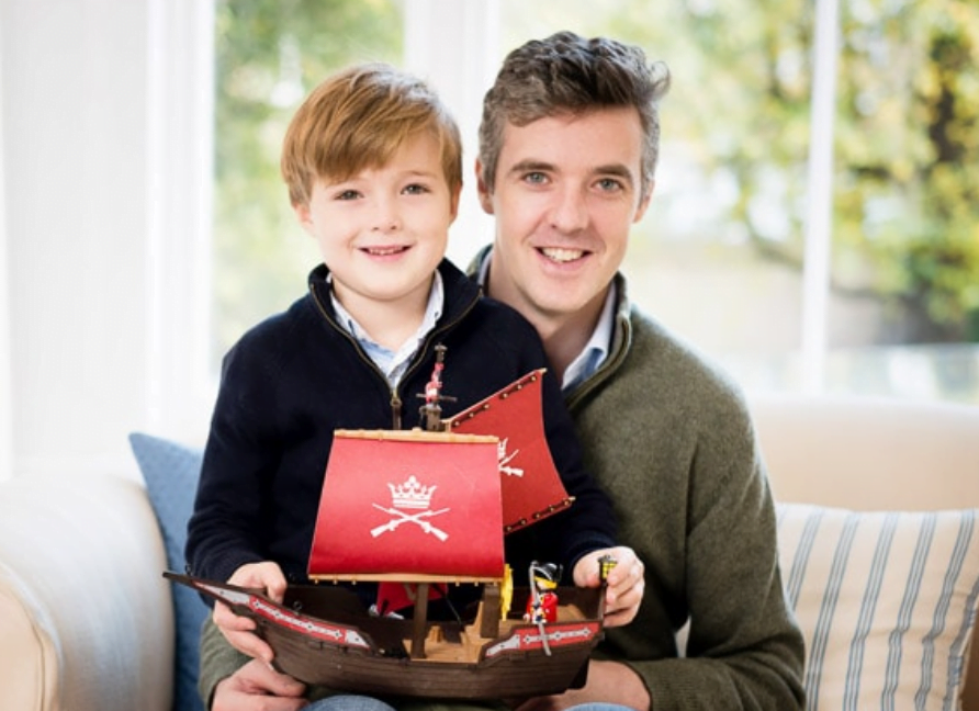 son and father photographed together in London sitting on sofa