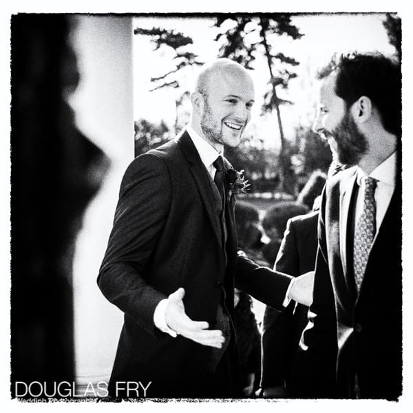 Groom welcoming guests at Hampton Court taken on Leica camera - black and white