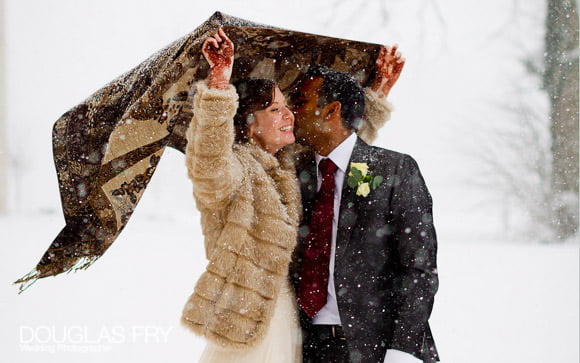 Couple photographed in Snow holding blanket