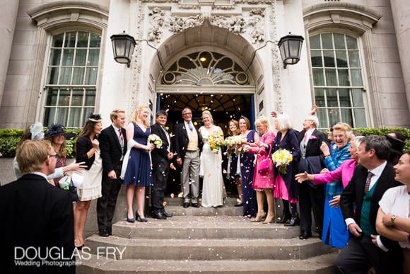 Wedding Photographer The Cavalry and Guards Club - Tara & Tim 4 Couple and guests on steps at Chelsea Register office on the Kings Road