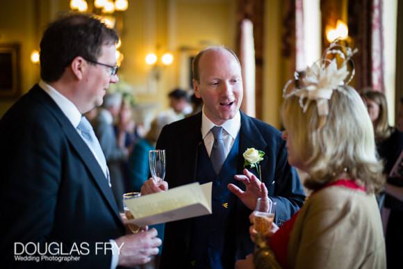Groom with guests during wedding reception in London