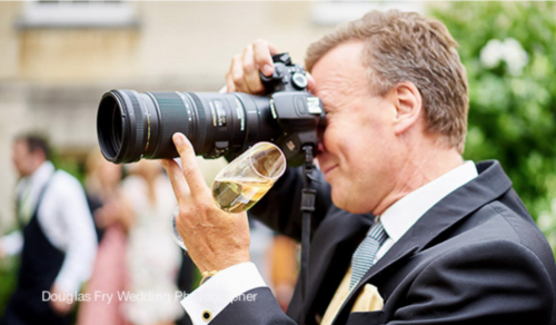 Wedding guest photographed with a large camera durind the reception