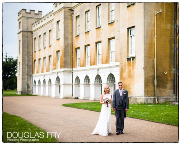 Bride and groom walking with Syon House behind