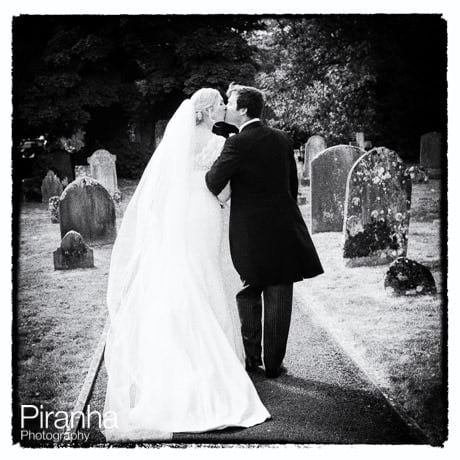 Black and white photograph of bride and groom in graveyard of Crudwell church