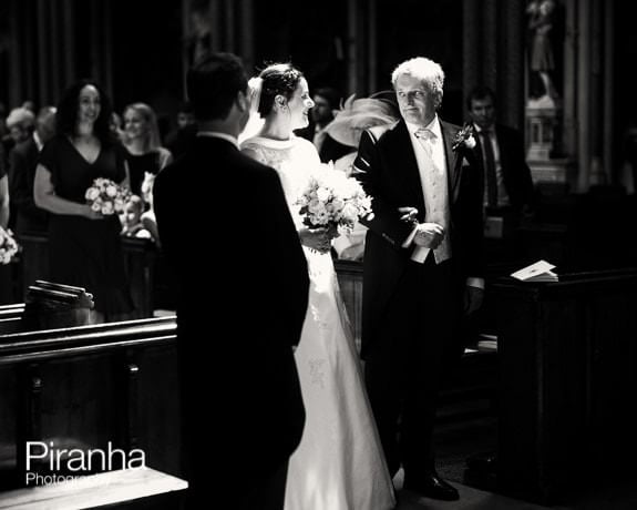 Wedding service at Farm Street Church with bride, groom and father of the bride in black and white