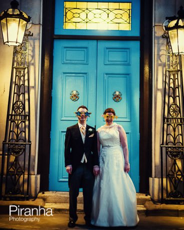 Bride and groom in comedy specatales in front of Stationers' Hall in London during wedding reception