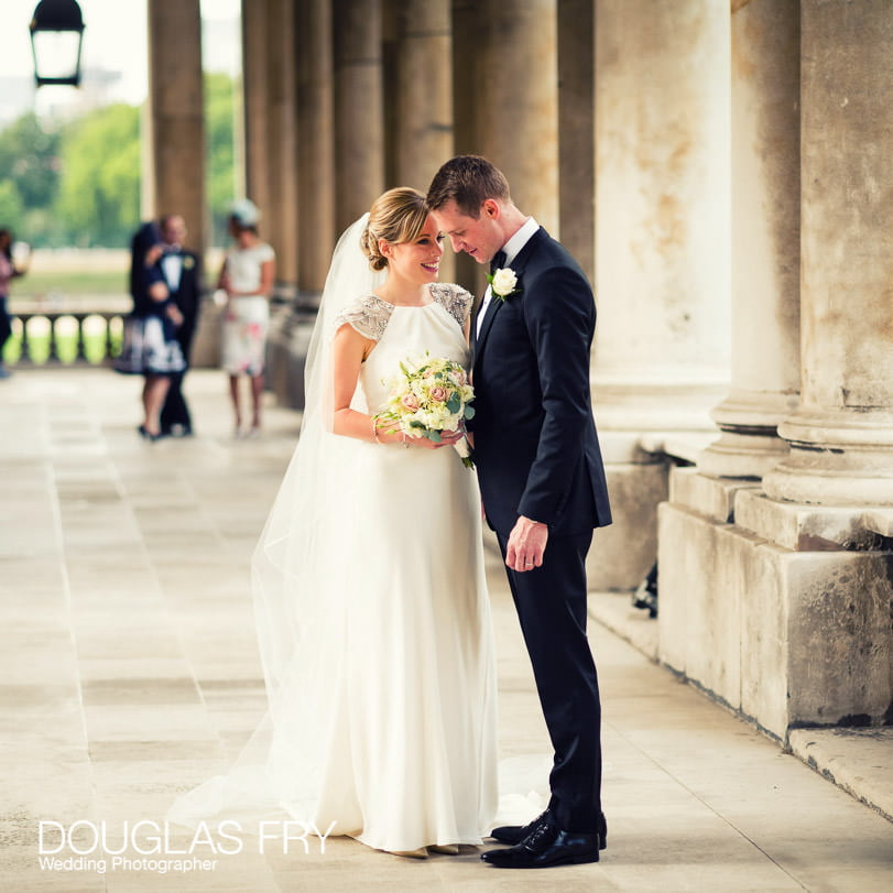 Wedding photograph of bride and groom talking outside Admirals House, Old Royal Naval College in Greenwich