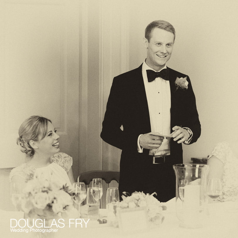 Black and white photograph of groom making speech during wedding breakfast in Greenwich