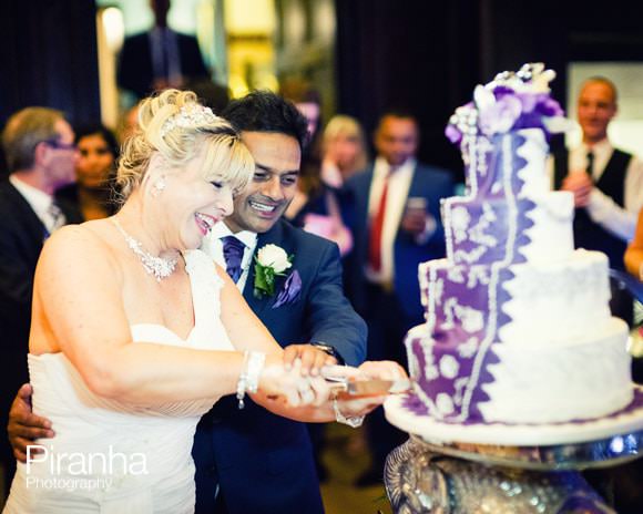 bride and groom cutting wedding cake in London