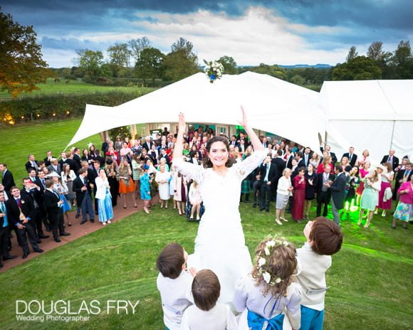 Bride throwing bouquet with bridesmaids and page