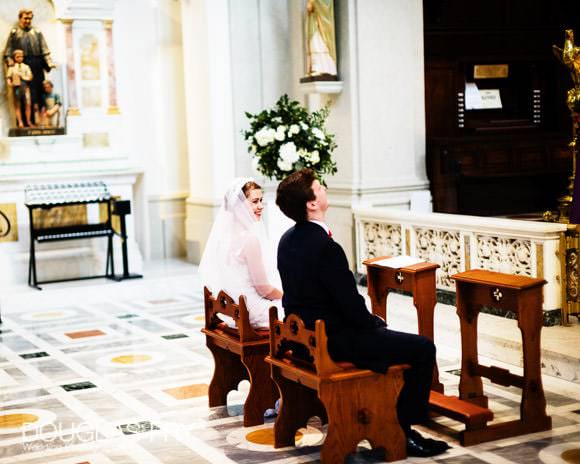 Bride and groom sitting in church during ceremony in Soho, London