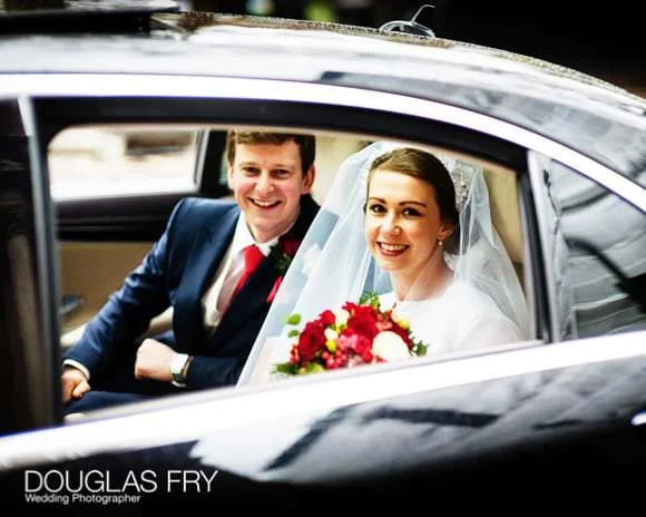 In and Out Club Wedding Photographer (Naval and Military Club) for Charlotte and Robert 5 couple in car leaving church for the wedding reception venue - In and Out club