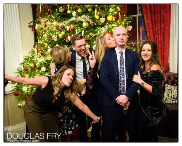 In and Out Club Wedding Photographer (Naval and Military Club) for Charlotte and Robert 7 In and Out Club wedding photograph of guests in front of Christmas tree
