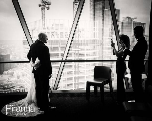 Bride and groom photographed by guests at the Gherkin