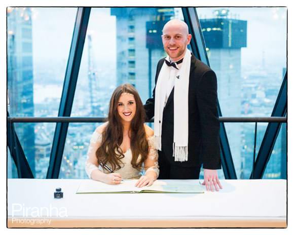 Couple signing the register during wedding ceremony