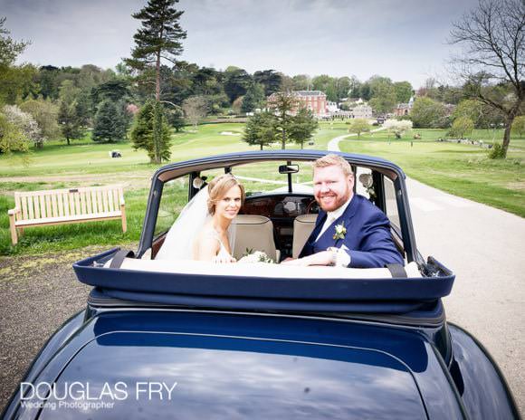 Bride and groom in car in front of RAC Epsom