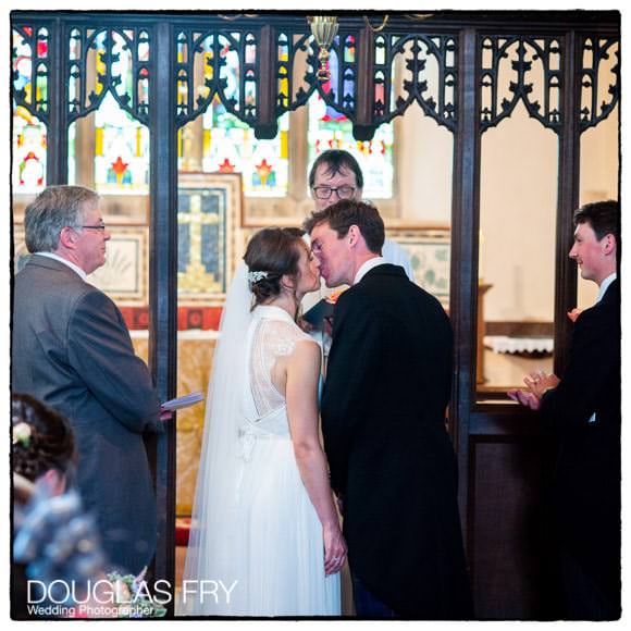 Bride and Groom kissing during wedding ceremony in Gloucestershire