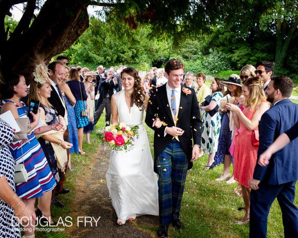 Couple leaving church with confetti - Gloucestershire