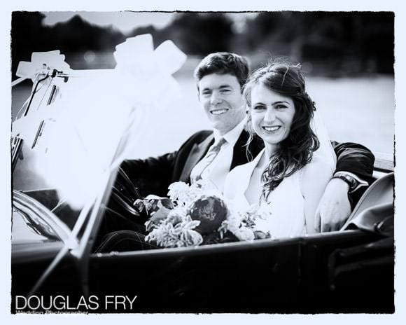 Black and white photograph of couple in wedding car